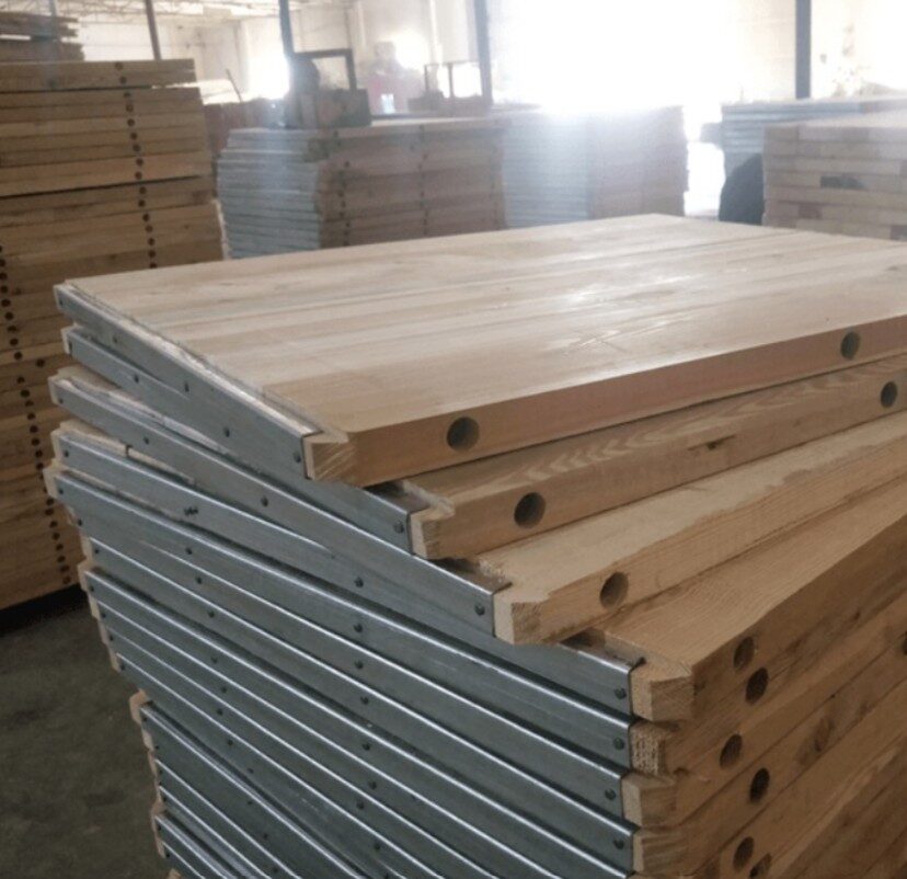 Close-up of Woodage block machine pallets showing galvanized steel end caps and groove joint construction